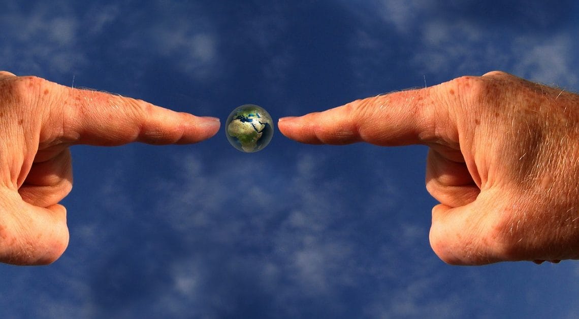 Fingers pointing at planet earth emphasising green values